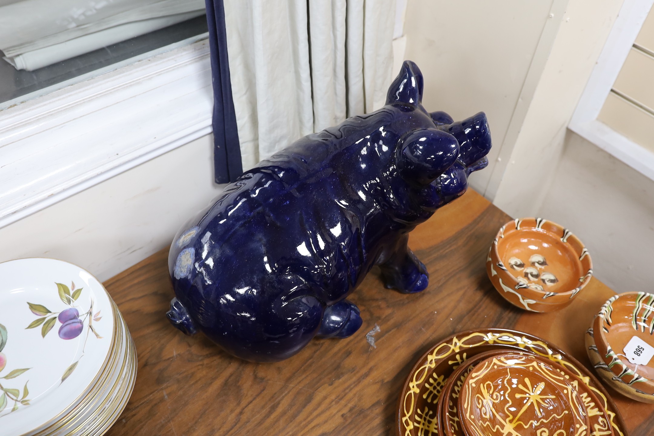 A large seated blue glazed pottery pig, 53cms wide